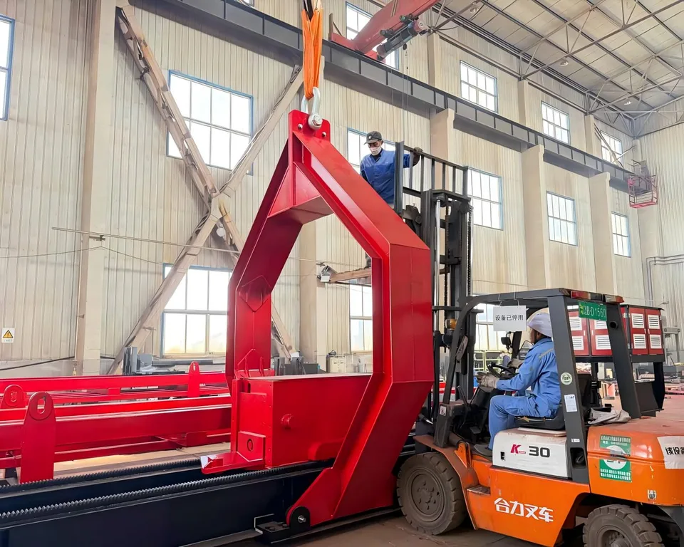 Workers using a forklift and overhead lifting equipment to position a red extractor frame